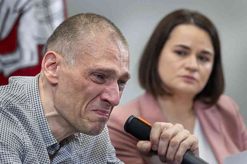 Syarhei Tsikhanouski, left, a Belarusian opposition activist released from a Belarusian prison, cries as his wife Belarusian opposition leader Sviatlana Tsikhanouskaya attends a news conference in Vilnius, Lithuania, Sunday, June 22, 2025. (AP Photo/Mindaugas Kulbis)