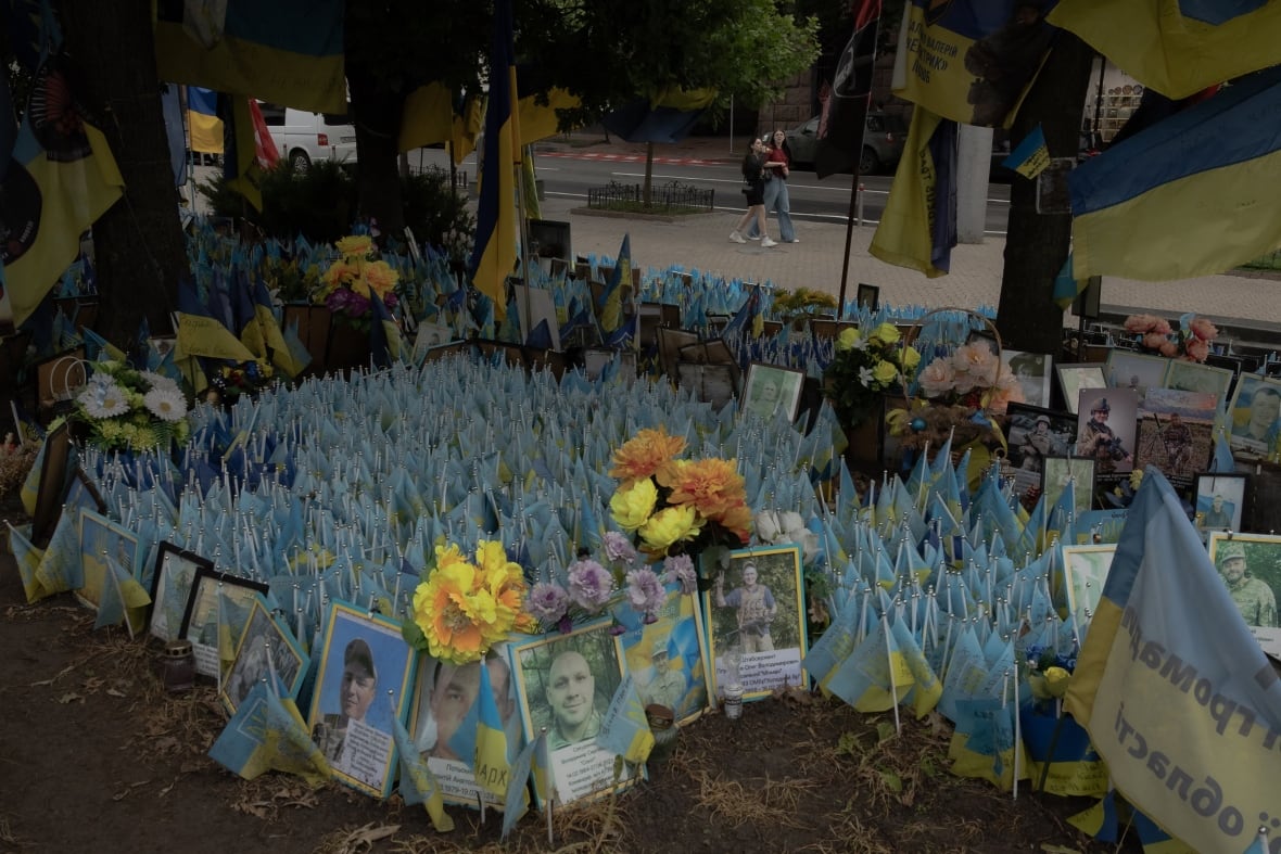 People walk past a memorial for the fallen Ukrainian and foreign fighters on the Independence Square in Kyiv on June 2, 2025.