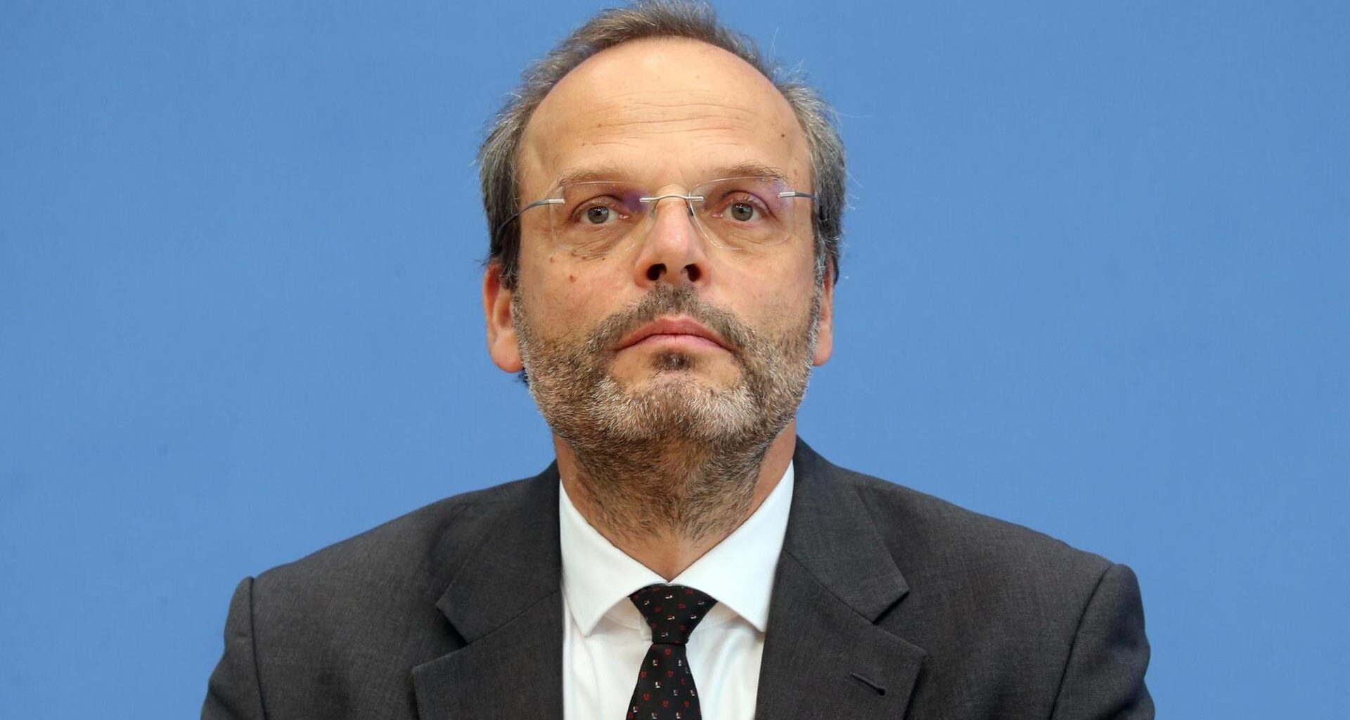 Felix Klein sitzt während einer Pressekonferenz mit ernstem Gesicht vor einer blauen Wand.