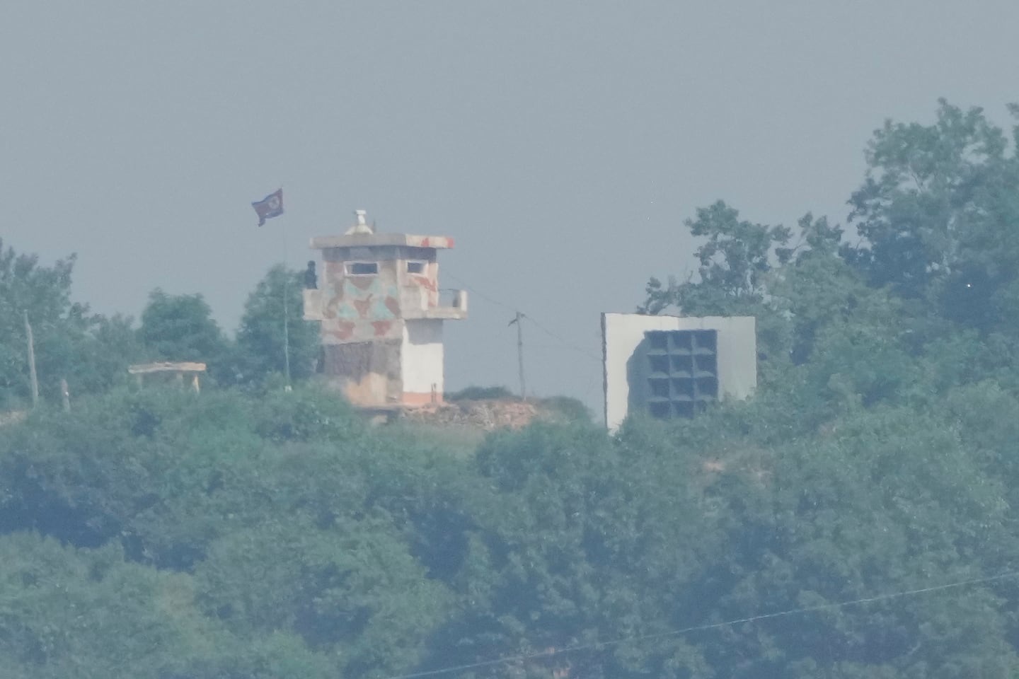 A North Korean military guard post, left, and loudspeaker are seen from Paju, South Korea, near the border with North Korea, on June 12.