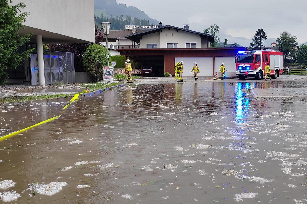 Feuerwehrleute auf einem überschwemmten Parkplatz in Fügen (Tirol)