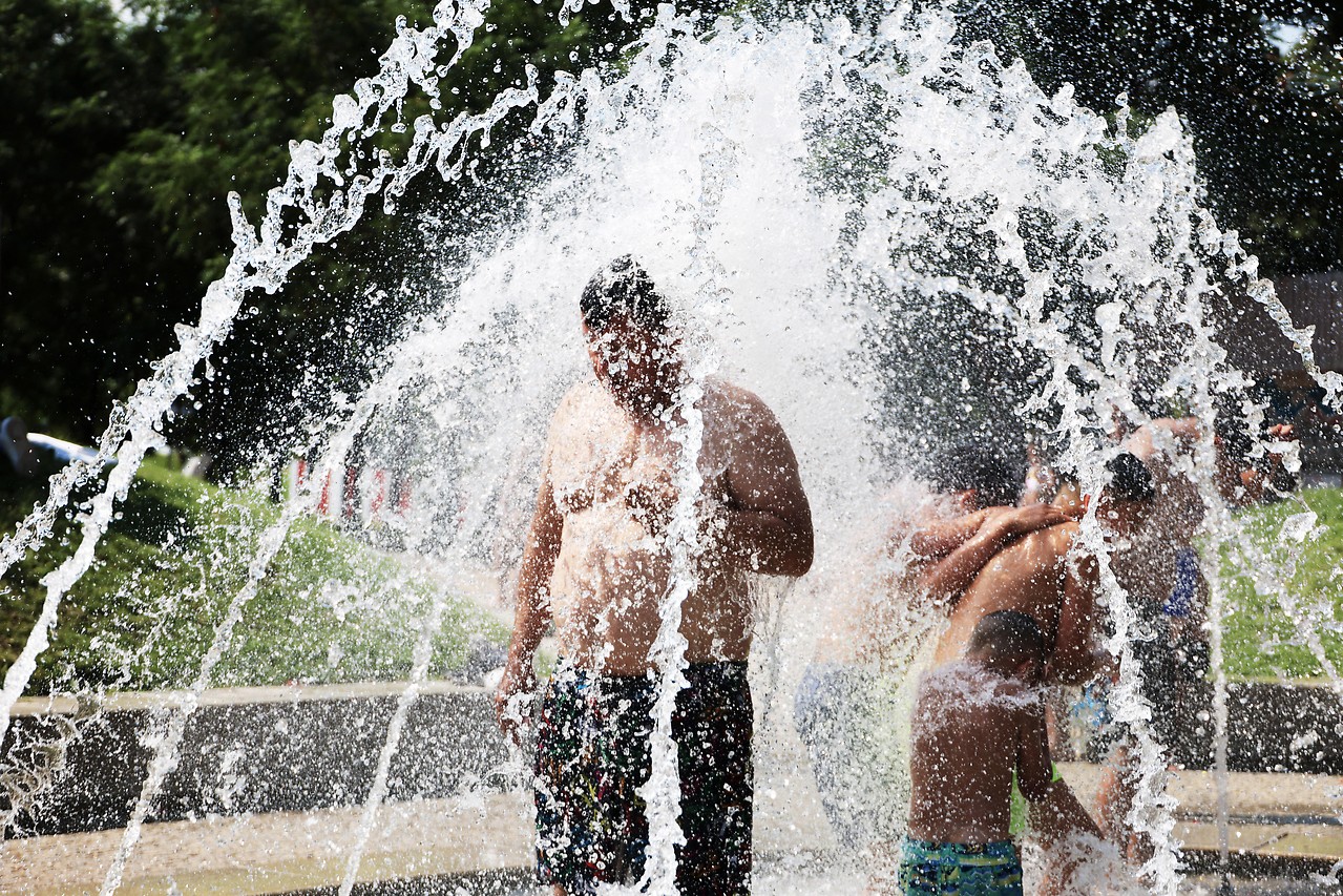 Ein Mann kühlt sich in einer Wasserfontäne in einem Brunnen in Madrid ab