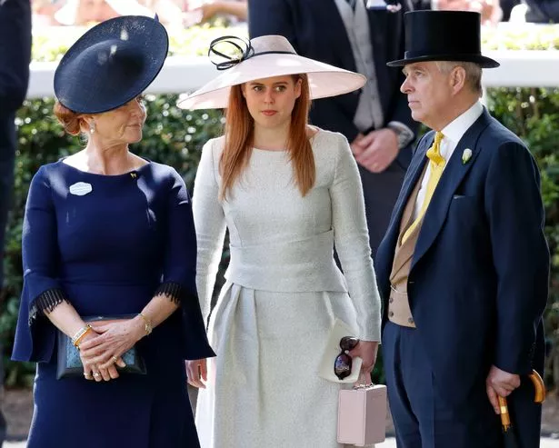 Left to right: Sarah Ferguson wearing a dark blue dress and hat, Princess Beatrice wearing a white dress and hat, and Prince Andrew wearing a dark blue top hat, dark blue suit and yellow tie. He is also holding an umbrella by his side.