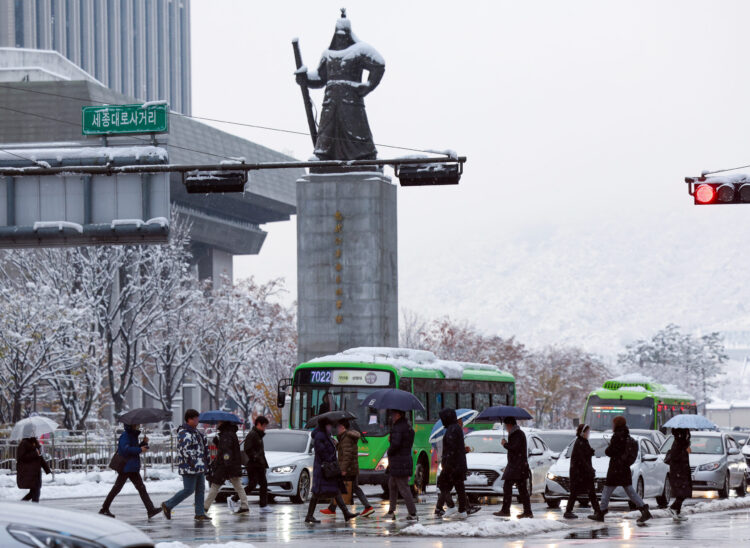 People commute to work through Gwanghwamun Square in Seoul on Nov. 28, 2024, during the second day of heavy snowfall. (Photo: IANS/Yonhap)
