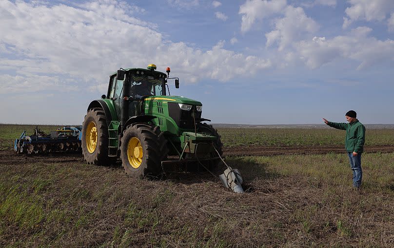 A tractor pulls out a part of a Russian rocket in an agricultural field during the sowing campaign in the Zaporizhzhia region, Ukraine.