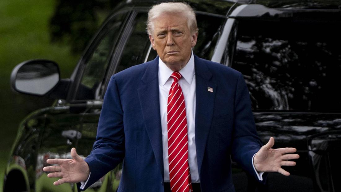 Donald Trump steht hinter einem Auto und breitet die Arme aus