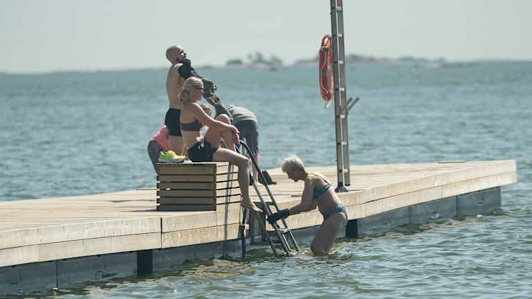 People getting in and out of the water on a pier.
