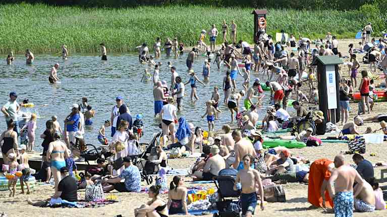 People enjoying a sunny day on a beach in Espoo.