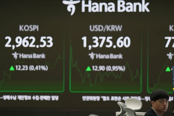 A dealer watches computer monitors near the screens showing the Korea Composite Stock Price Index (KOSPI), left, and the foreign exchange rate between U.S. dollar and South Korean won at a dealing room of Hana Bank in Seoul, South Korea, Wednesday, June 18, 2025. (AP Photo/Lee Jin-man)