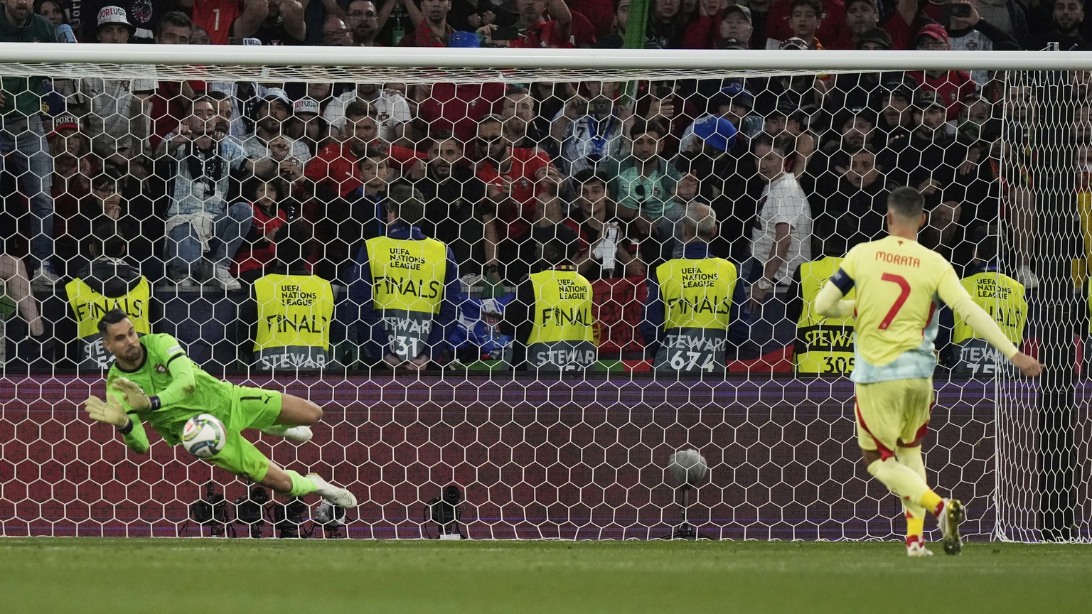 Portugal goalkeeper Diogo Costa makes a save against Spain's Alvaro Morata during the penalty shootout of the Nations League final soccer match between Portugal and Spain at the Allianz Arena in ...