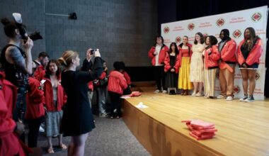 City Year student success coaches pose for group photos at their graduation ceremony inside the Academy of Natural Sciences in Philadelphia on Friday. The AmeriCorp programs graduated 77 volunteers after a funding cut instituted by the Department of Government Efficiency.