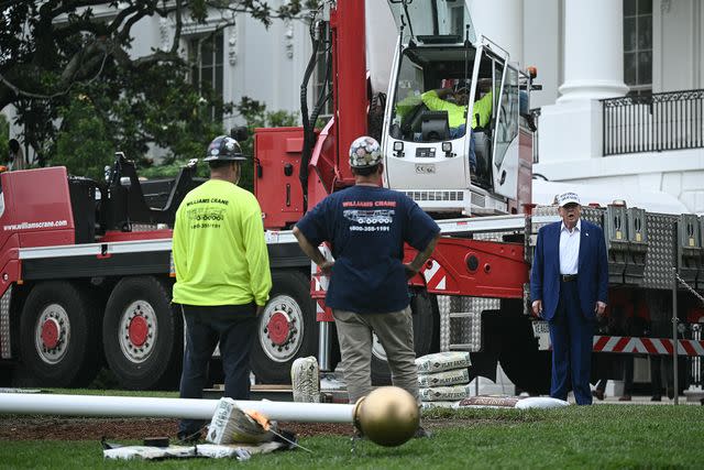 BRENDAN SMIALOWSKI/AFP via Getty  President Donald Trump with workers in front of the White House on June 18.