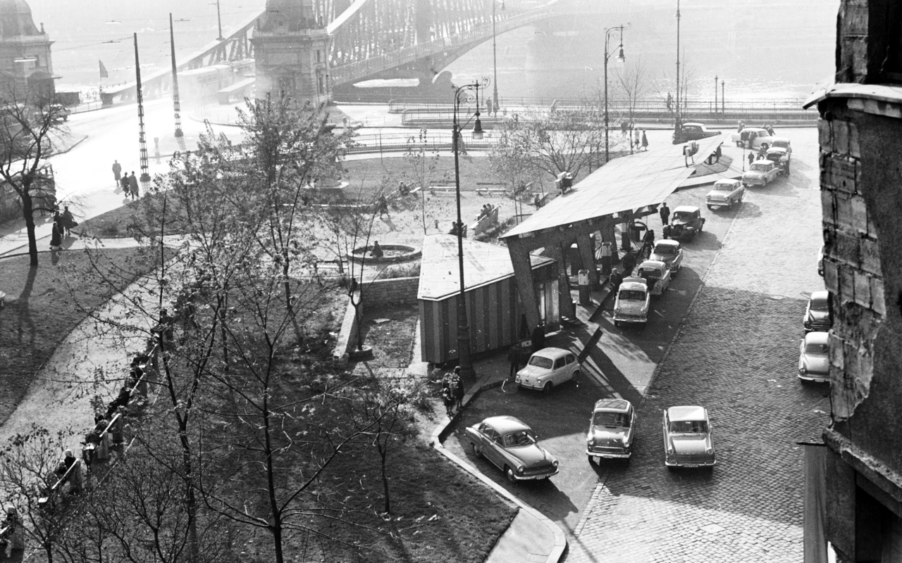 1963 - a Szabadság híd pesti hídfőjénél egy (mára megszűnt) benzinkúton állnak sorban az autósok. A motorizáció és az ipari fejlődés robbanásszerűen növelte a kőolajtermékek, így a benzin vagy gázolaj iránti keresletet. A nagykapacitású finomító idővel nem csak a belföldi igényeket elégítette ki, de kelendő exporttermékek előállítására is alkalmassá vált.  
