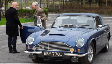King Charles getting out of his blue Aston Martin