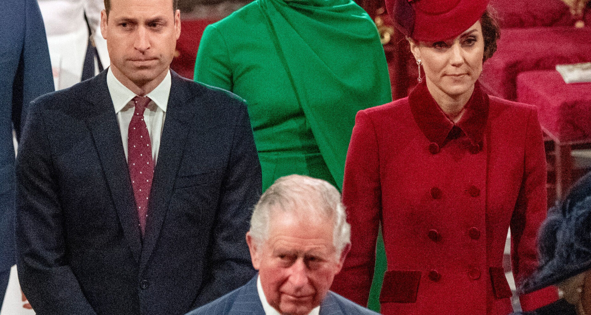 Prince William is wearing a dark suit with a red tie, while Kate Middleton wears a red coat dress and matching hat, and King Charles walks ahead of them in a striped blue suit
