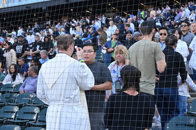 Churchgoers receive communion during the Archdiocese of ChicagoÕs Catholic mass hosted at Rate Field, home of the Chicago White Sox.