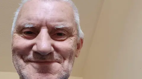 Bob Pritchard Bob smiles down at the camera in a selfie with a white ceiling in the background