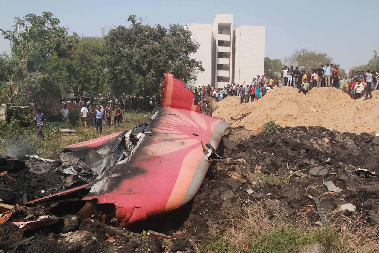 (250612) -- AHMADABAD, June 12, 2025 (Xinhua) -- People look at the debris of an Air India plane crashed in Ahmedabad of India's Gujarat state, June 12, 2025.  An Air India flight to London with 242 people on board, including two pilots and 10 cabin crew members, crashed Thursday shortly after takeoff from an airport in the western Indian state of Gujarat, officials said. Senior police officer confirms at least 110 dead in the crash, according to local media reports.    The flight took off from the Sardar Vallabhbhai Patel International Airport in Ahmedabad, about 17 km south of Gandhinagar, t