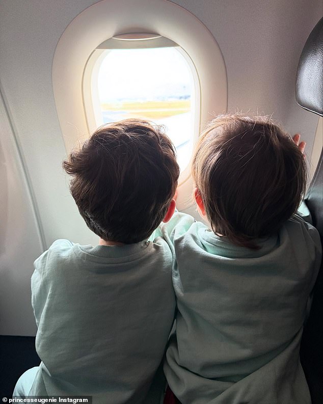 Ernest and August watch out of an airplane window in matching outfits