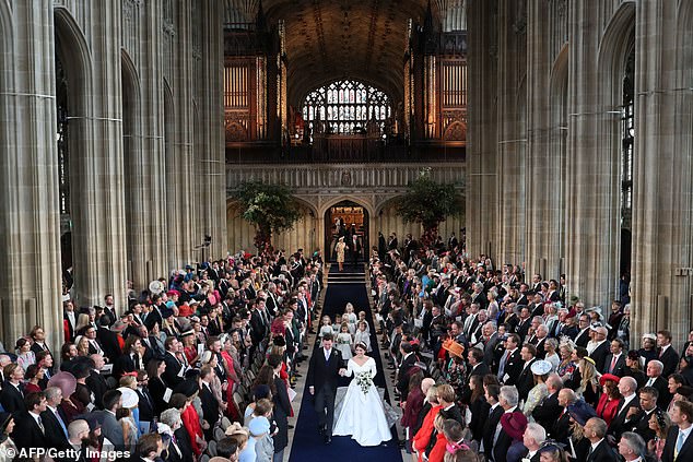 Eugenie and Jack walk back down the aisle of the Quire hand in hand at the end of their wedding ceremony at St George's Chapel