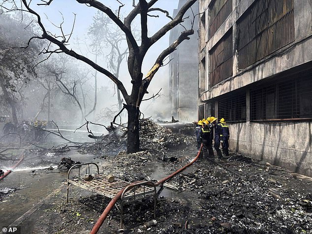 Firefighters working at the scene of the Boeing air crash in Ahmedabad, Gujarat state, India