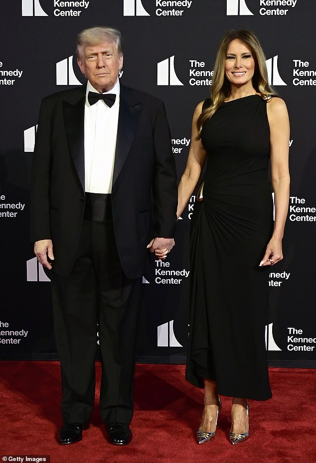 Donald Trump wore a simple, black tuxedo as he arrived at the Kennedy Center for the opening night of Les Misérables. His wife, Melania Trump, donned a $3,9000 black Bottega Veneta dress that contained a conservative neckline and gold embellishments on her hip and shoulders. She exuded elegance and glamour in the chic gown, which she paired with Christian Louboutin heels