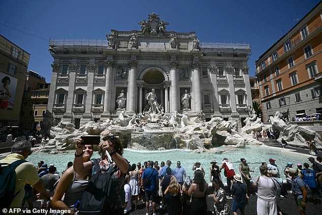 ITALY: Tourists visit the Trevi fountain during a hot summer day in Rome on June 26