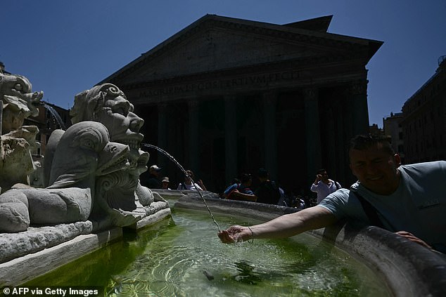 ITALY: A man refreshes himself with water at a fountain near Pantheon during a hot summer day in Rome on June 26