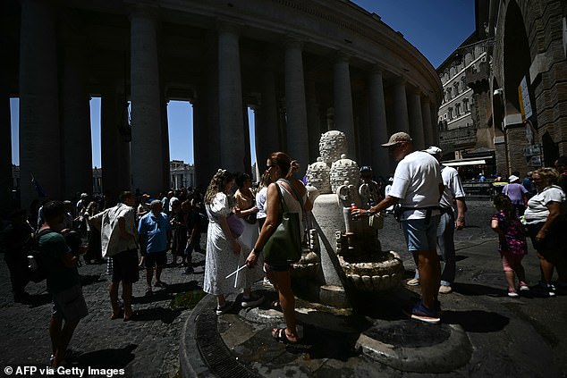 ITALY: People fill their bottles with water at a fountain near the Vatican on June 26