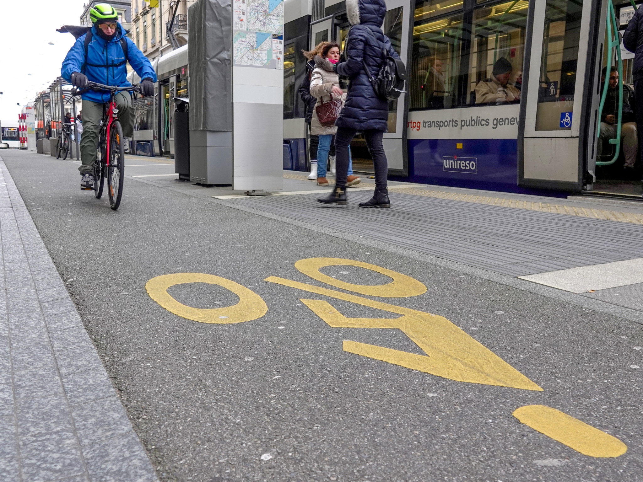 Un cycliste portant un casque sur la voie cyclable de la rue du Stand à Genève, à proximité d’un tram. Un cycliste portant un casque sur la voie cyclable de la rue du Stand à Genève, à proximité d’un tram.