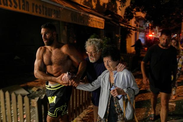 People evacuate after a missile launched from Iran struck Tel Aviv, Israel
