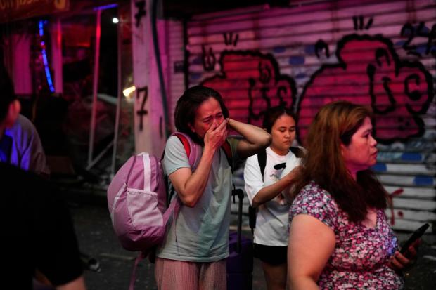 People evacuate after a missile launched from Iran struck Tel Aviv, Israel