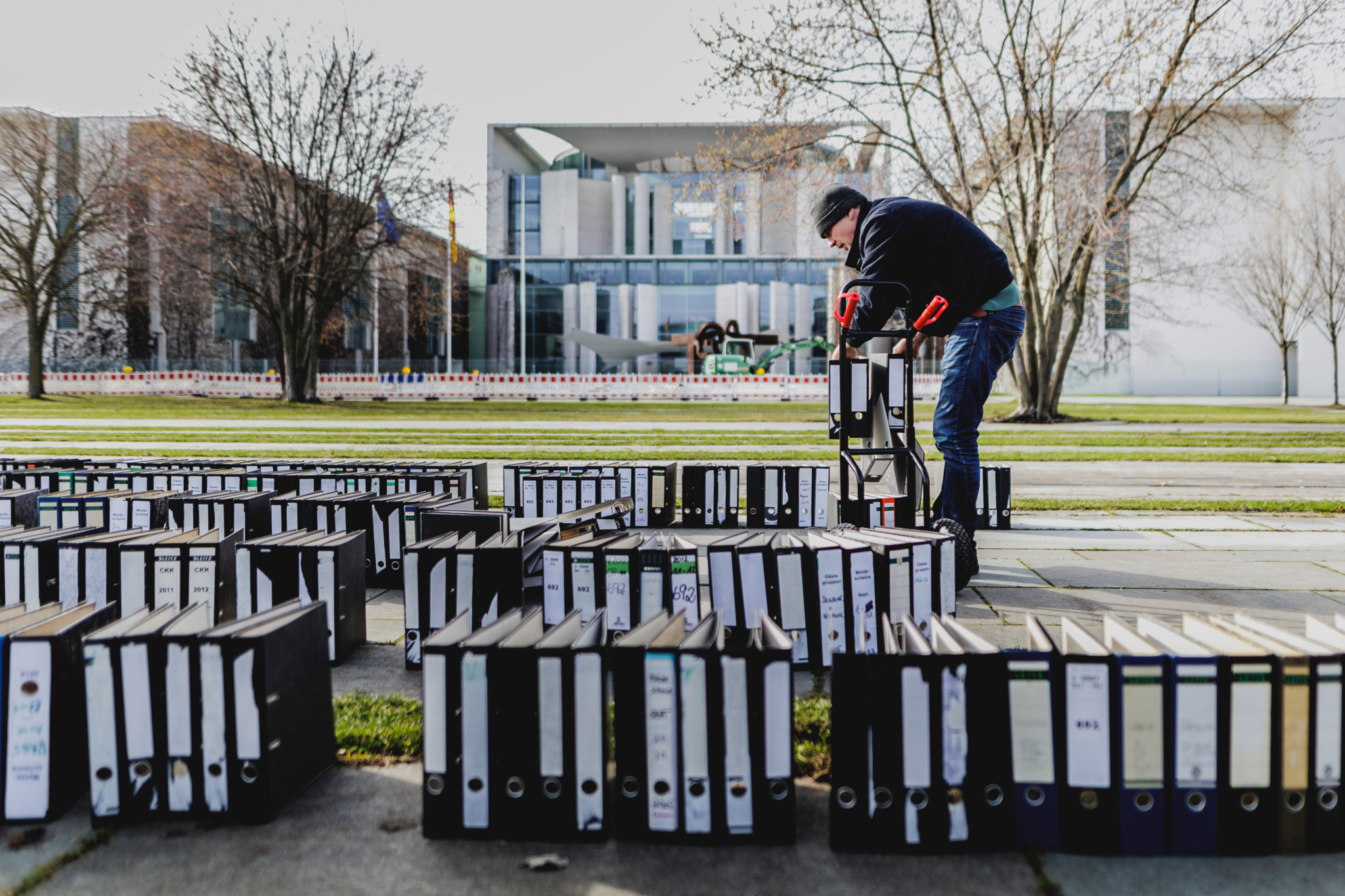 Ein Mann entfernt Ordner nach einem Protest des Zentralverbandes des Deutschen Handwerks vor dem Bundeskanzleramt in Berlin, 26. Februar 2024.