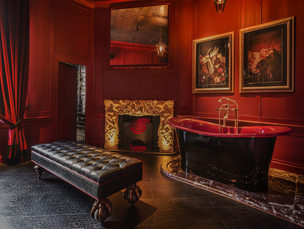bathroom of the townhouse apartment - red walls, freestanding black tub