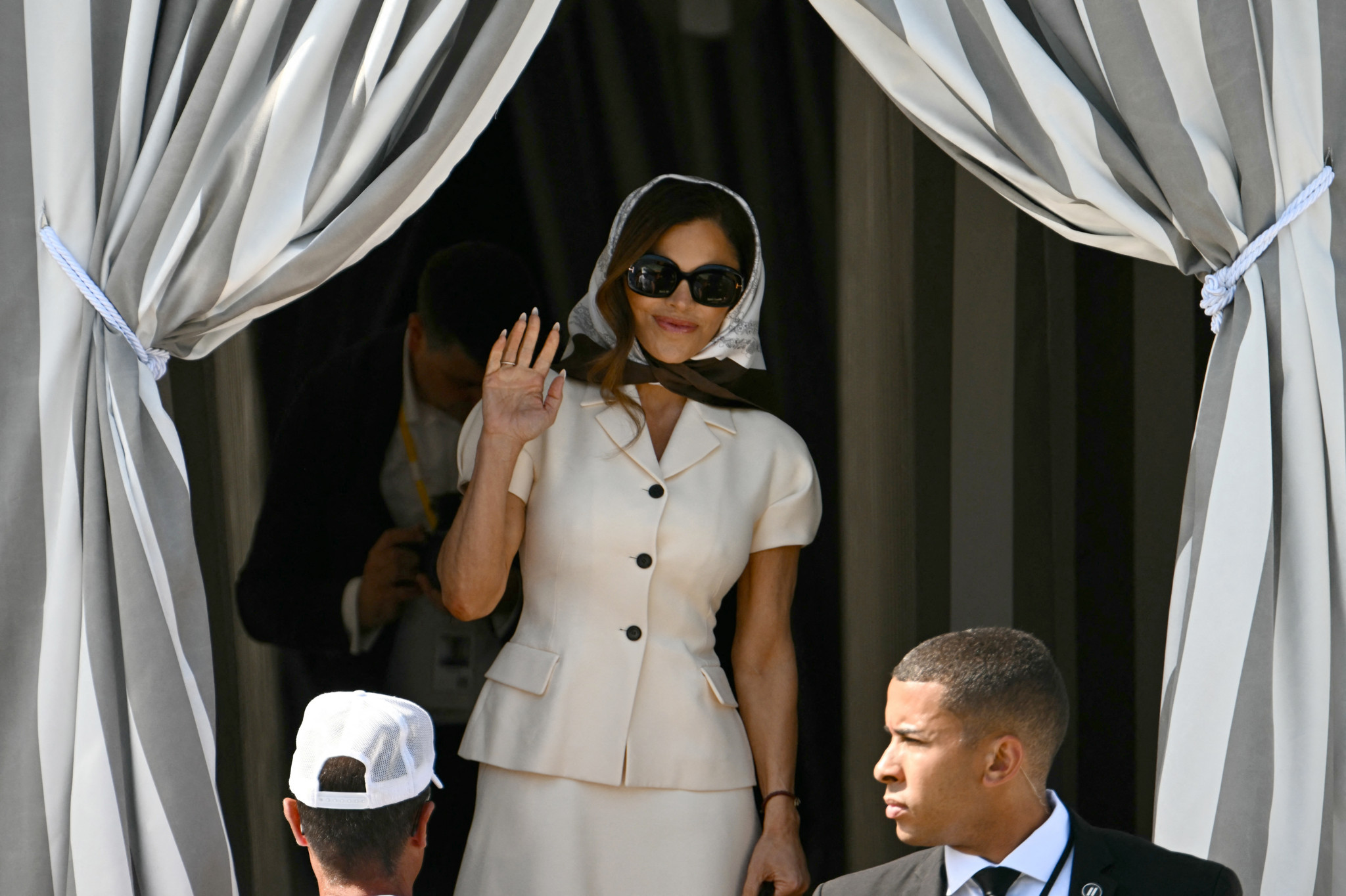 Lauren Sanchez sort de l’hôtel Aman à Venise le jour de son mariage avec Jeff Bezos, portant une tenue blanche et saluant. Lauren Sanchez sort de l’hôtel Aman à Venise le jour de son mariage avec Jeff Bezos, portant une tenue blanche et saluant.