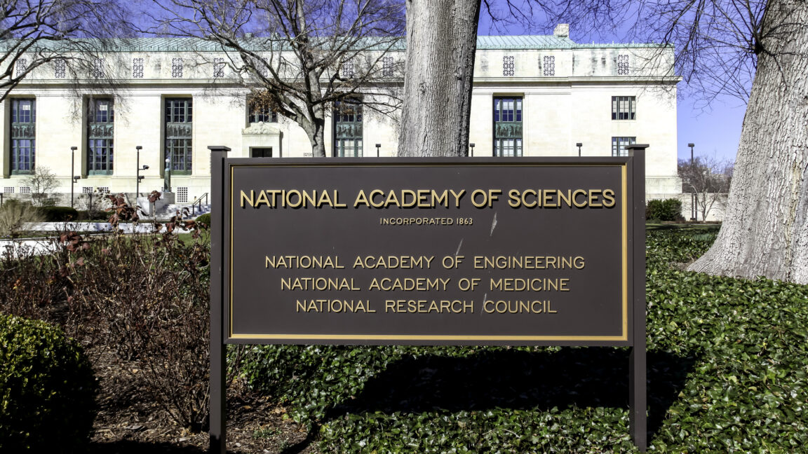 Image of a science in front of a marble building, declaring that the building hosts the National Academies of Science.