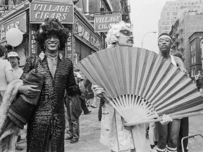 American gay liberation activist Marsha P. Johnson (1945-1992, center left) along with unidentified others, on the corner of Christopher Street and 7th Avenue during the Pride March, New York City, June 27, 1982.