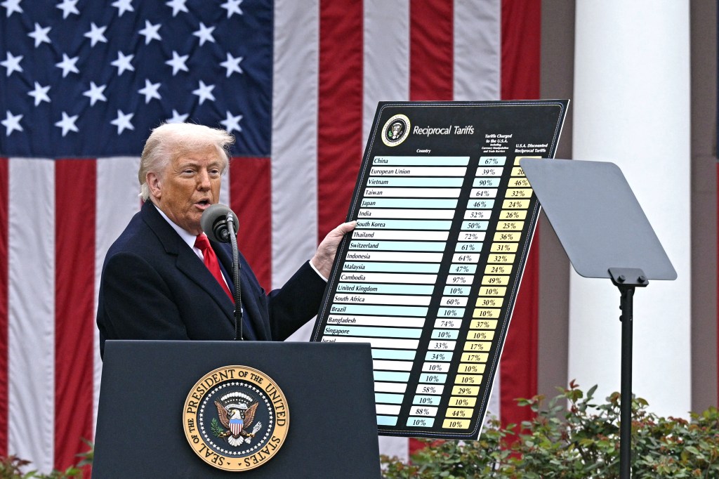 US President Donald Trump delivers remarks on reciprocal tariffs as US Secretary of Commerce Howard Lutnick holds a chart during an event in the Rose Garden entitled "Make America Wealthy Again" at the White House in Washington, DC, on April 2, 2025. Trump geared up to unveil sweeping new "Liberation Day" tariffs in a move that threatens to ignite a devastating global trade war. Key US trading partners including the European Union and Britain said they were preparing their responses to Trump's escalation, as nervous markets fell in Europe and America. (Photo by Brendan SMIALOWSKI / AFP) (Photo by BRENDAN SMIALOWSKI/AFP via Getty Images)