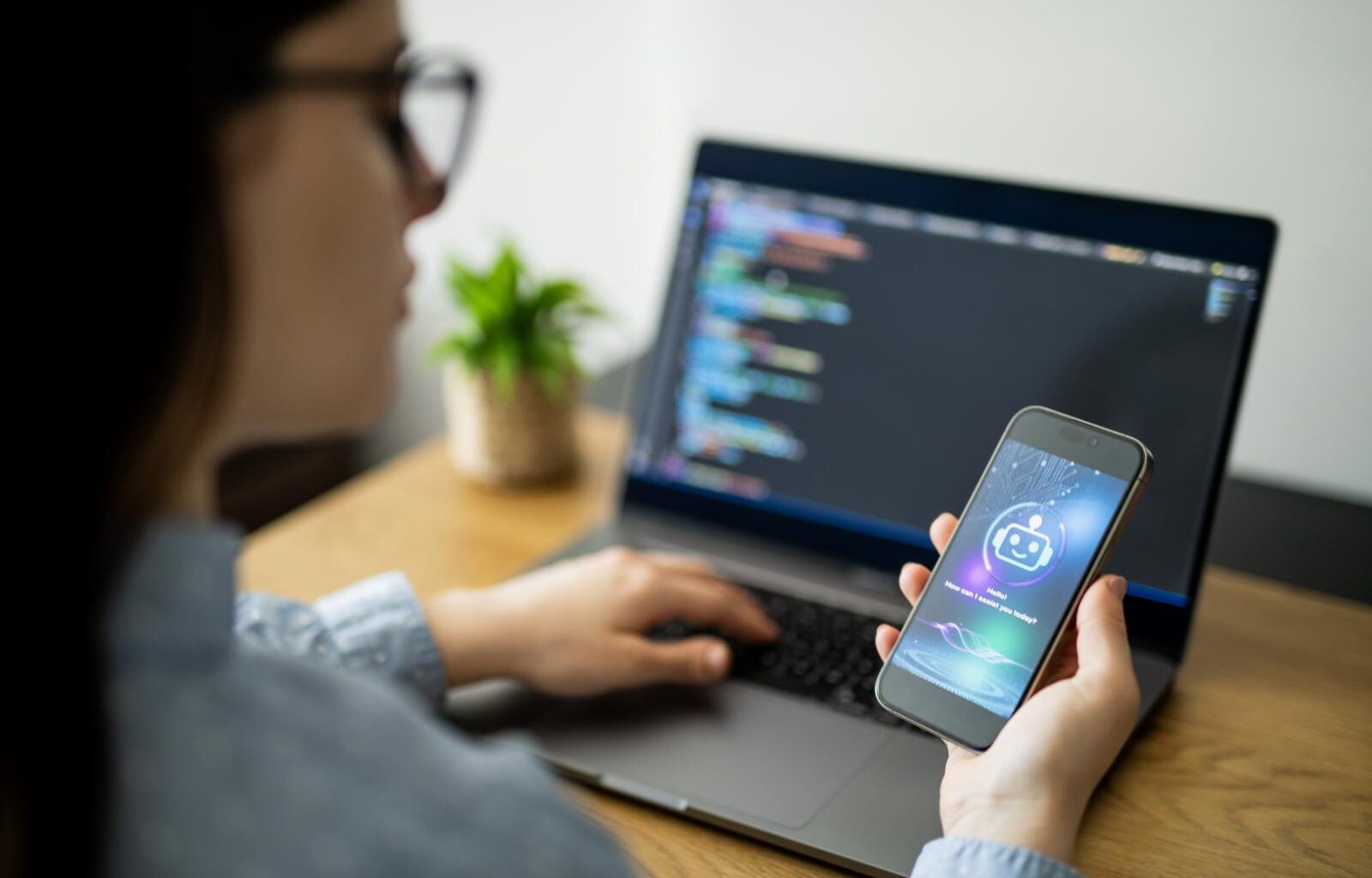 Woman with phone in front of computer