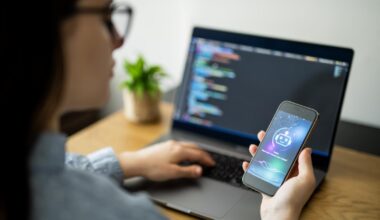 Woman with phone in front of computer