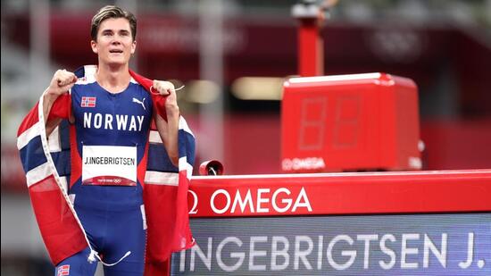 Jakob Ingebrigtsen of Norway drapes himself with the national flag after winning gold medal at Tokyo Olympics. (REUTERS)