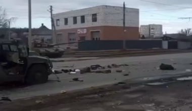 Ukrainian soldiers and police officers watch as a T-64B1VK tank targets School No. 134. After the strike, the fighters will proceed with a clearing operation. Kharkiv city, Kharkiv region.