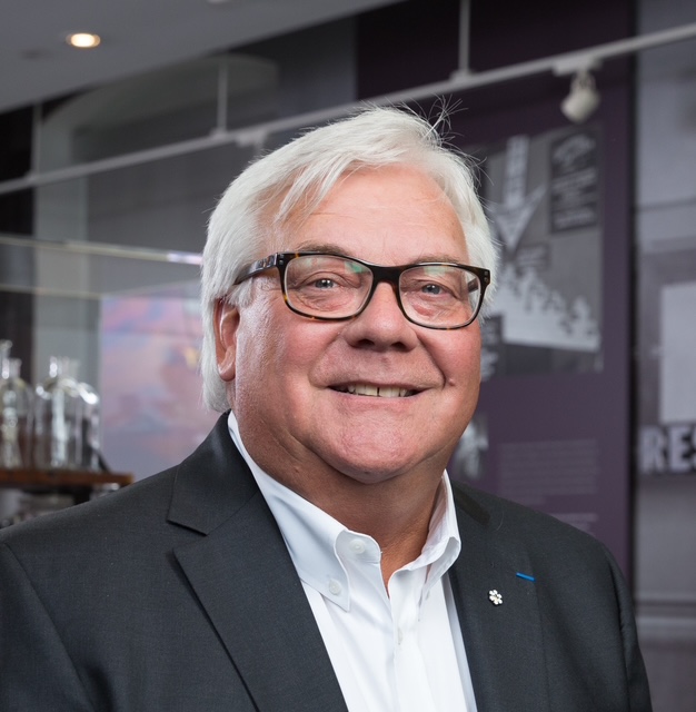 A head-and-shoulders shot of Mark Lievonen. He has white hair, dark-rimmed glasses and is wearing a suit jacket with an Order of Canada pin on the left lapel.