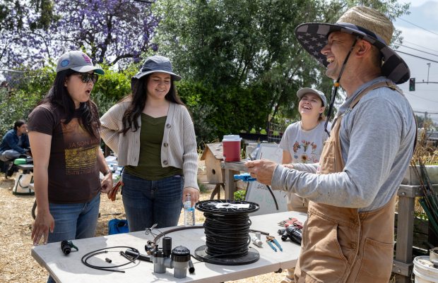 Landscape contractor Michael Sherman, right, teaches a lesson on irrigation...