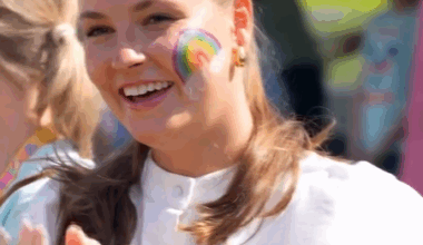 Princess Ingrid Alexandra of Norway wears face paint in the pattern of a rainbow as she prepares to make candyfloss at a children's festival