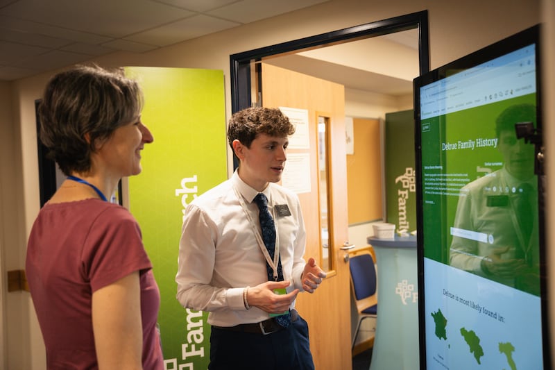 A volunteer explains services offered by FamilySearch at the open house for the first Latter-day Saint meetinghouse in Strassen, Luxembourg, June 14-15, 2025.