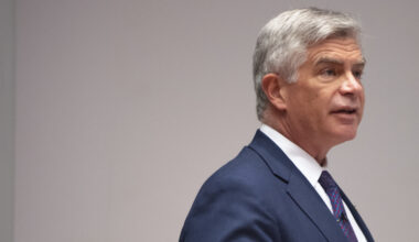 Side view of Philadelphia Fed Presiden Harker speaking at a podium