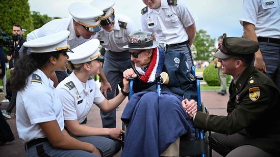 Attendees shared a lighthearted moment with 102-year-old World War II and D-Day veteran Jake Larson, affectionately known as “Papa Jake,” ahead of a memorial ceremony at the American Cemetery in Colleville-sur-Mer on June 6, 2025. (Photo by Lou BENOIST / AFP)(AFP)