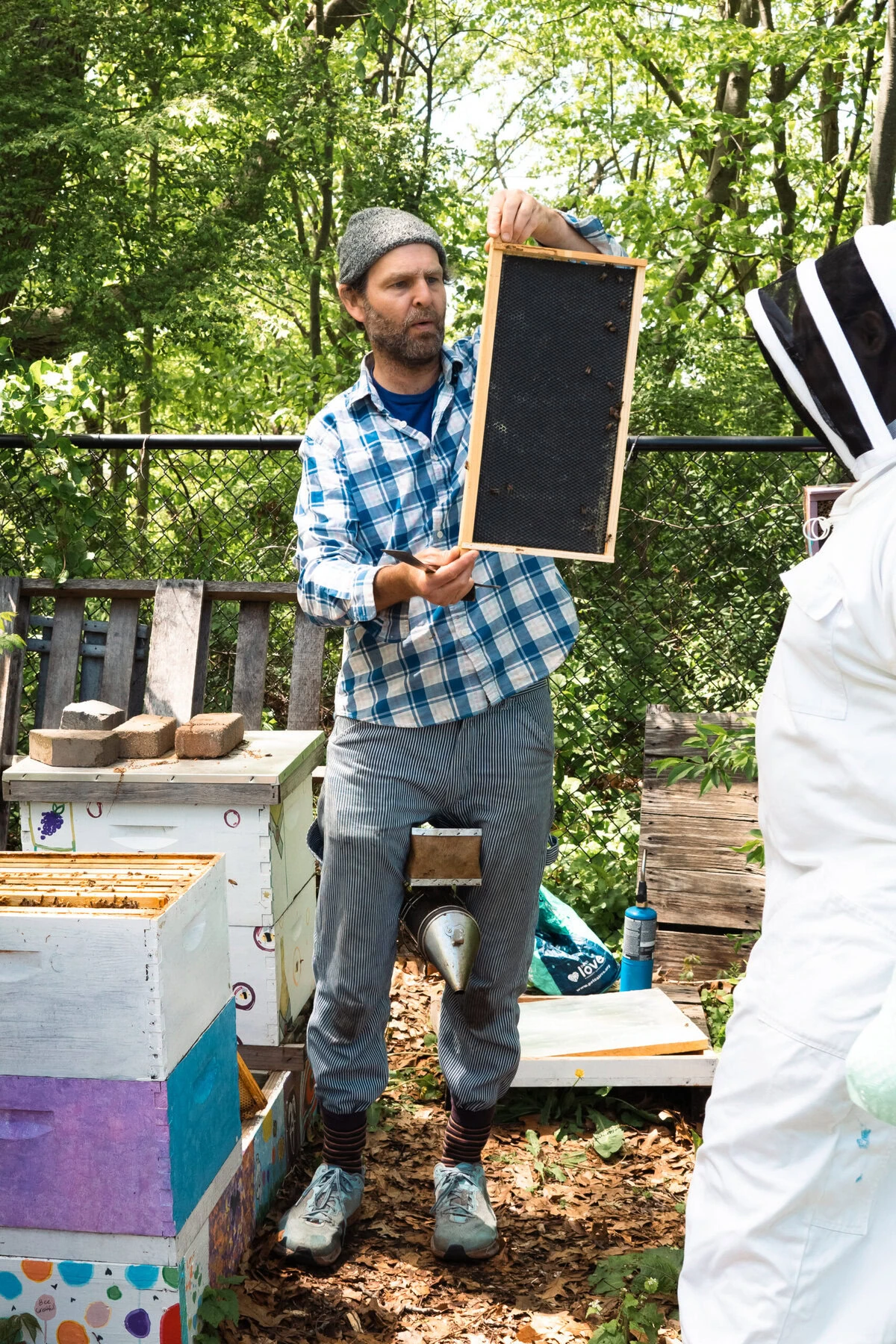 Tim Dutcher, lead beekeeping instructor for the Huneebee Project, shows off a frame during a hive check.