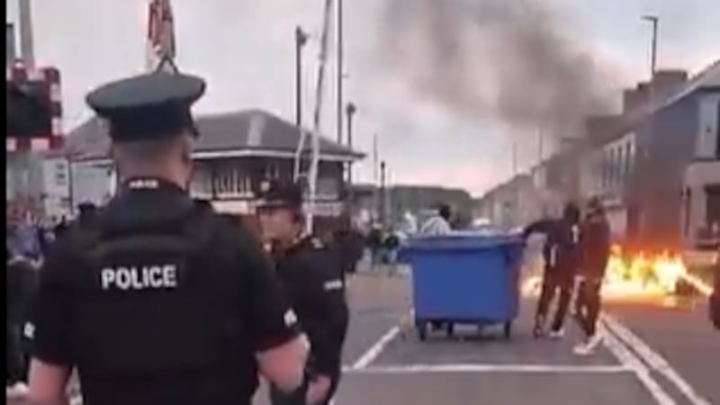 PSNI fail to intervene as wheelie bins placed onto burning railway barricade during race-hate protest 